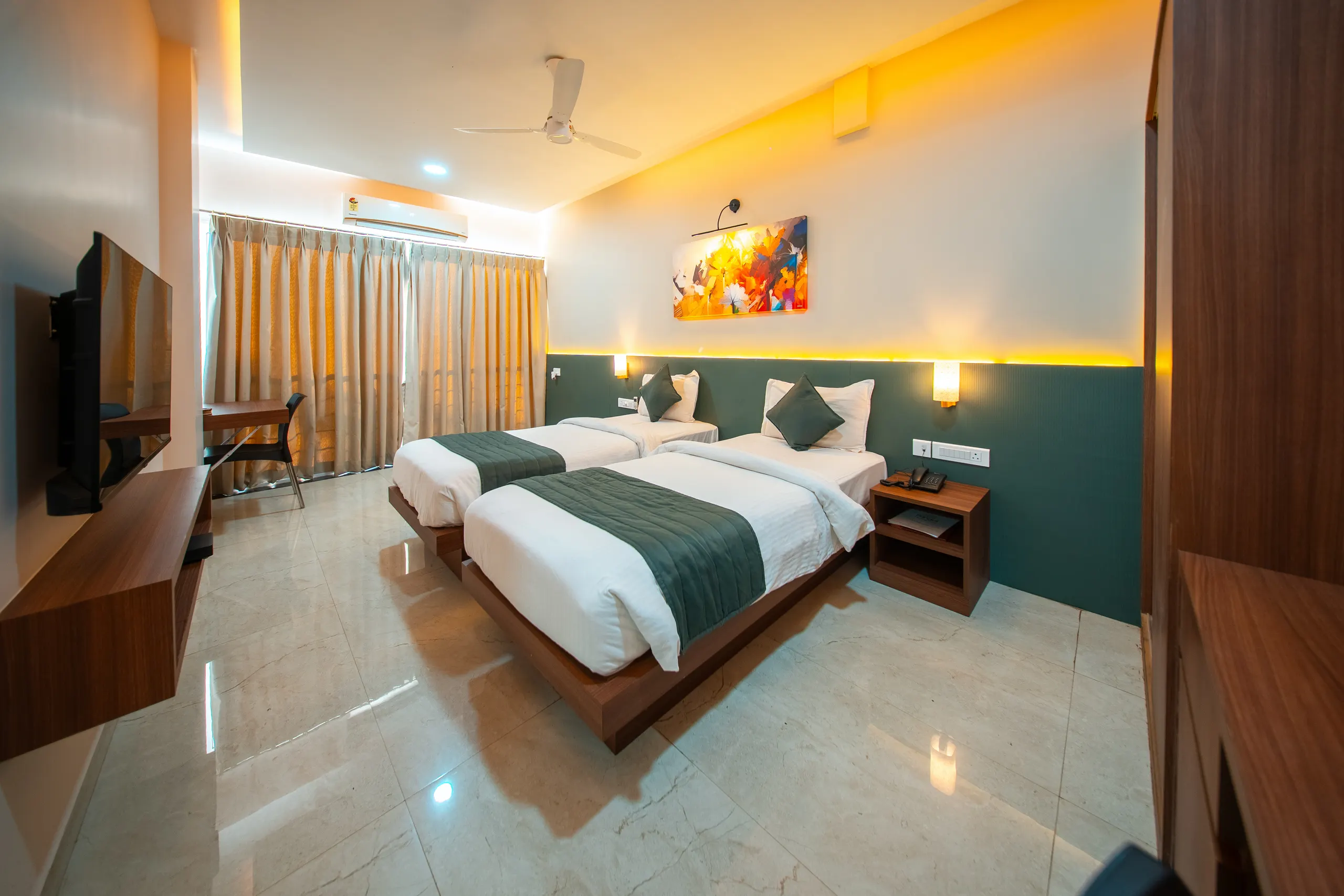 An Executive Twin room from the doorway, twin beds and desk under warm lighting